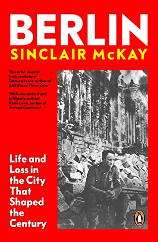 Book cover: red background, black text, and a black and white photo of a man amid rubble.