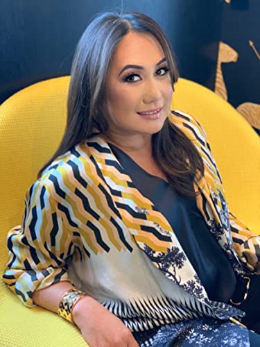A woman with long brown hair sits in a yellow chair wearing a patterned jacket.