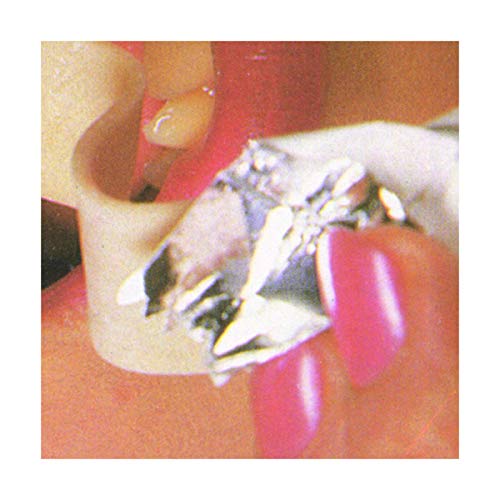 Close-up of red fingernails holding a jagged, silver object.