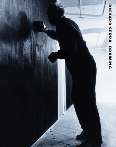 Silhouetted artist applying black material to a dark wall.