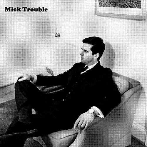 Black and white album cover featuring a man sitting in a chair.