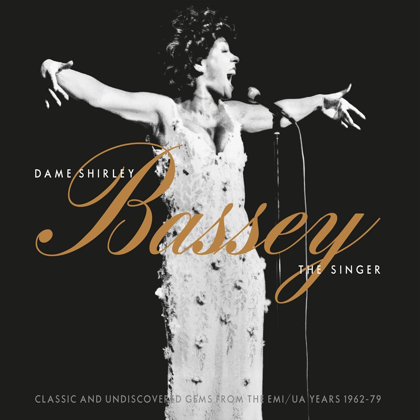 Shirley Bassey in a sparkling gown performing with a microphone.