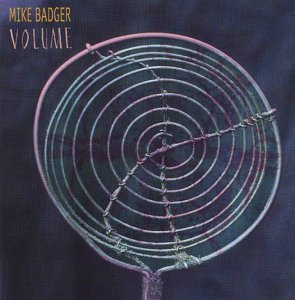 CD cover for "Mike Badger - Volume" featuring abstract circular design.