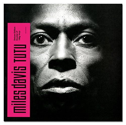 "Vinyl album cover featuring a black-and-white close-up of Miles Davis' face with pink text."