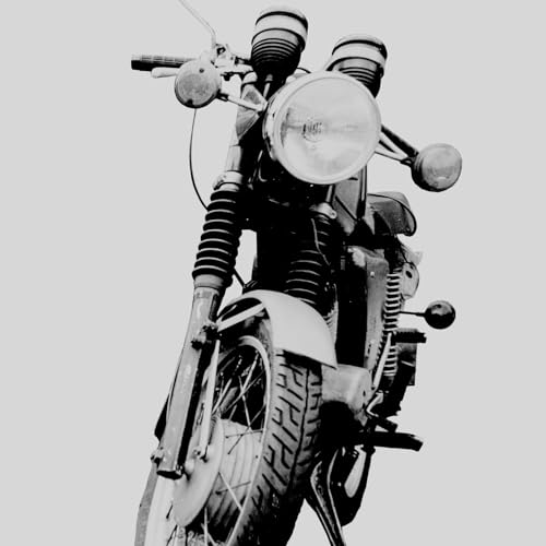Low-angle black and white photograph of a vintage motorcycle against a plain background.