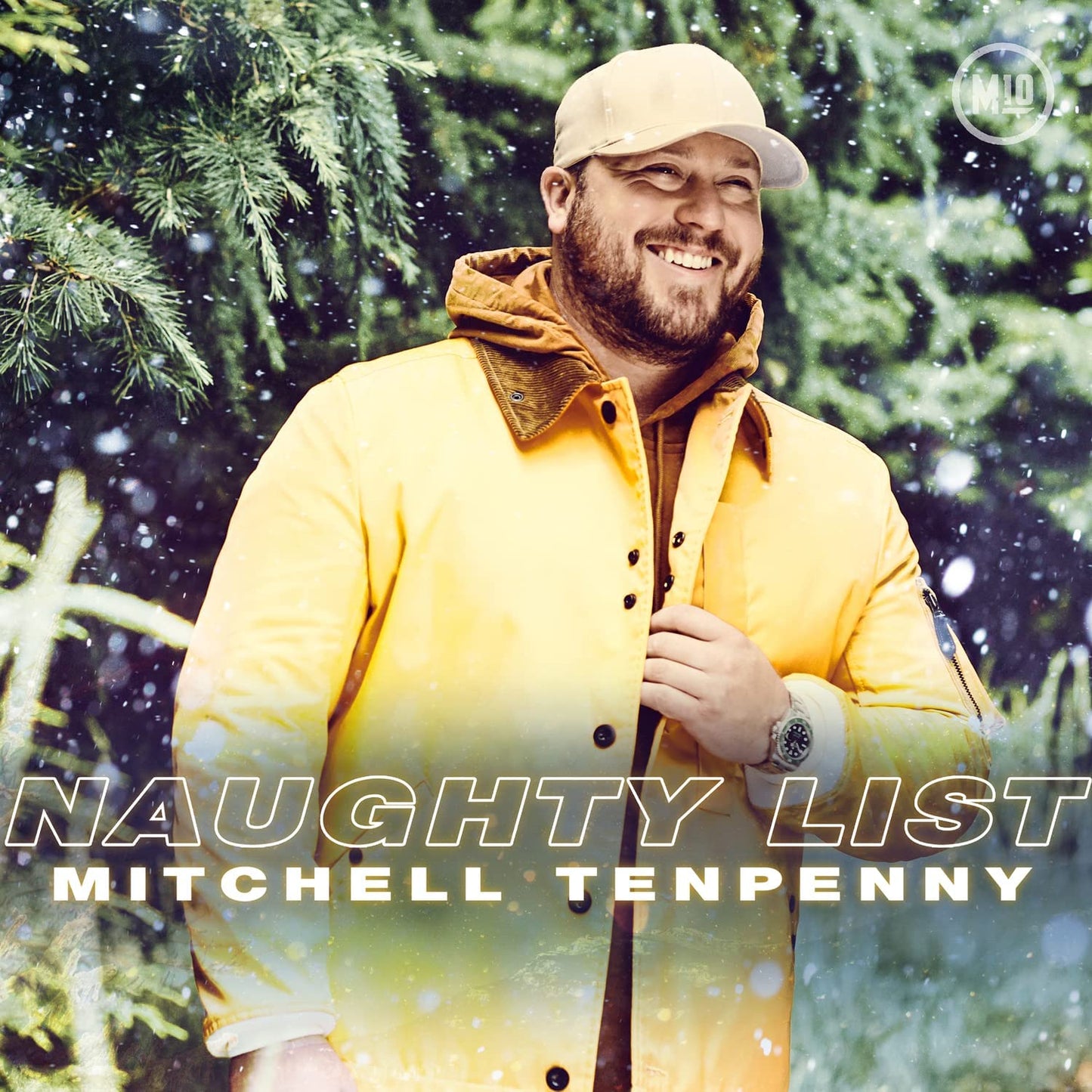 Mitchell Tenpenny smiles, wearing a yellow jacket, with "Naughty List" text.