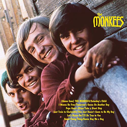 The Monkees' debut album cover featuring three smiling band members.