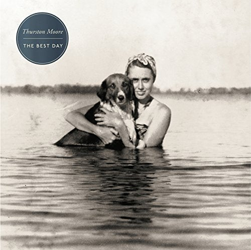 Vintage photo of a woman and dog embracing in water.