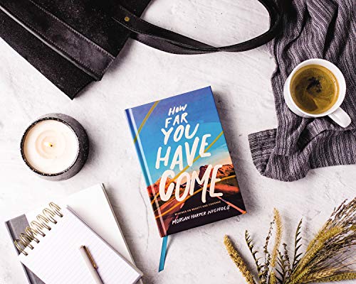 Book titled “How Far You Have Come” with coffee, candle, and notebook.