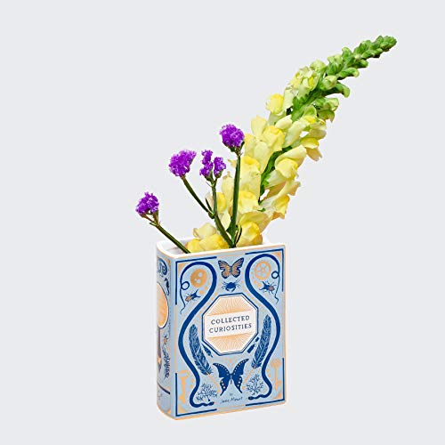 Ceramic vase shaped like a book, with flowers inside, illustrated design.