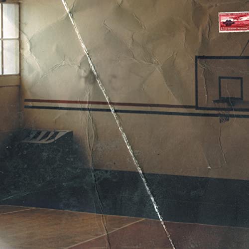 Indoor basketball court with a cracked floor and a vintage postcard.