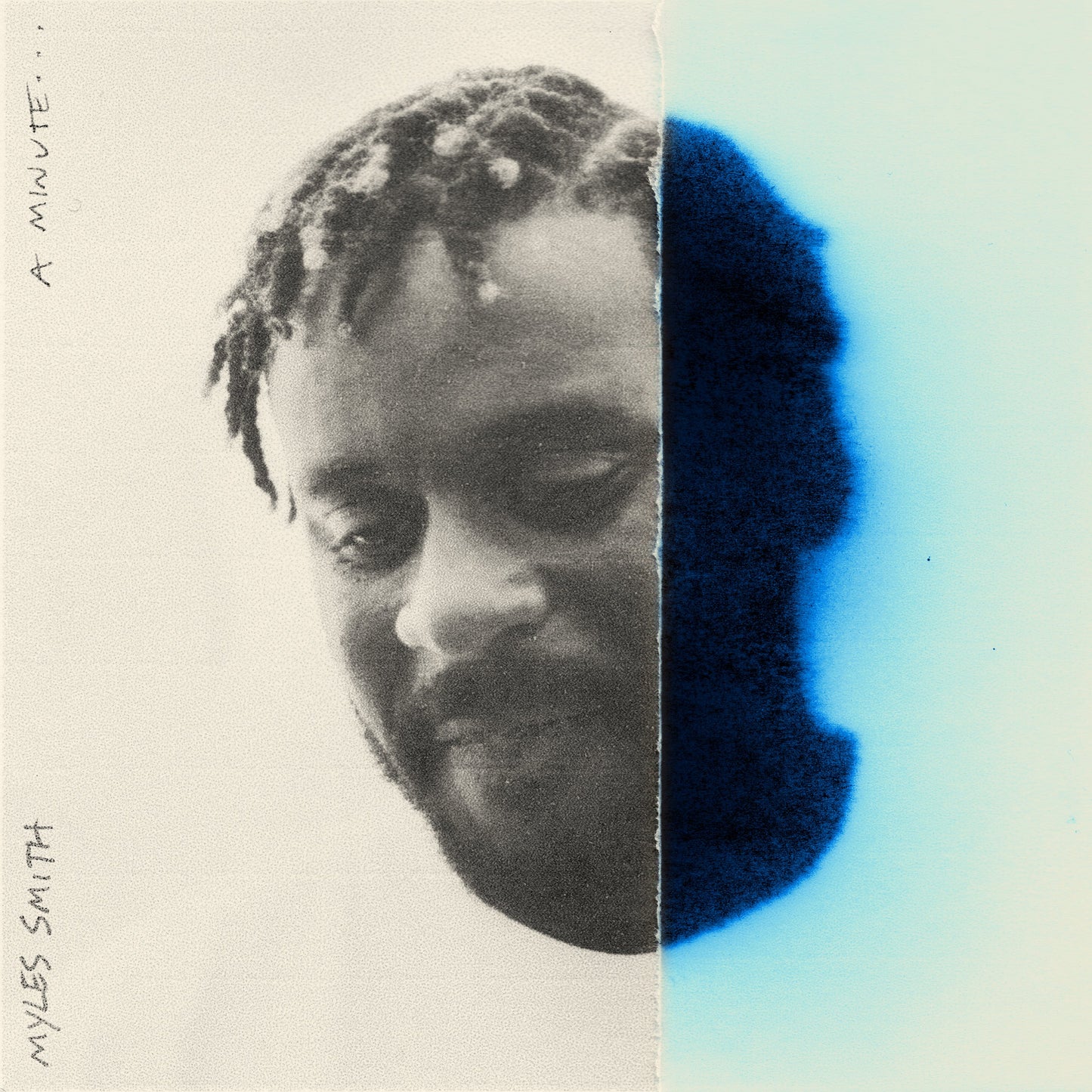 A black and white portrait of Myles Smith partially obscured by a blue ink stain.