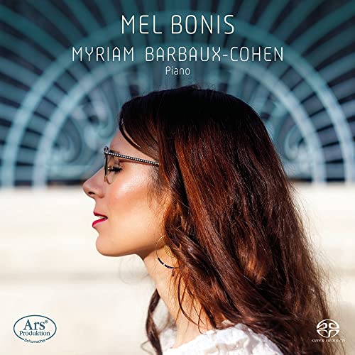 Profile portrait of pianist Myriam Barbaux-Cohen wearing glasses against a blue architectural background.