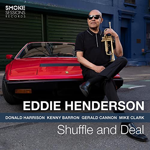 Eddie Henderson wearing sunglasses and holding a trumpet, sitting on a red sports car.