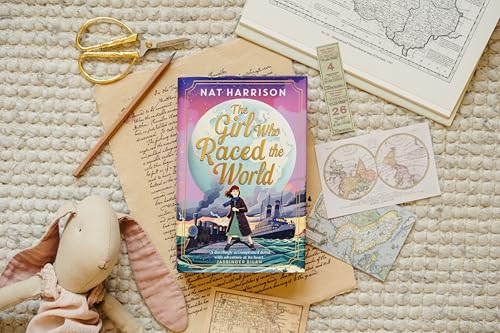 The book The Girl Who Raced the World surrounded by maps, a toy, and scissors.