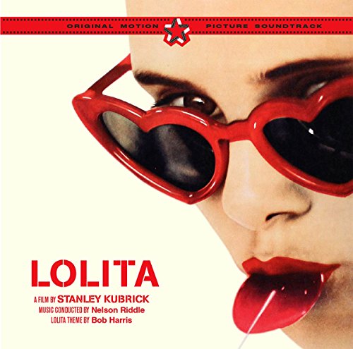 Close-up of a person wearing red heart-shaped sunglasses and licking a red lollipop.