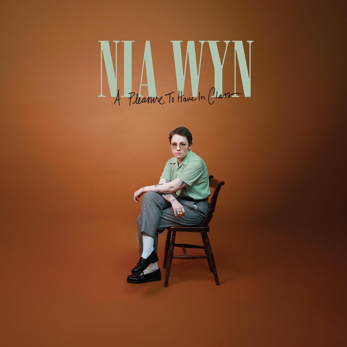 CD cover featuring Nia Wyn, a person sitting on a wooden chair.