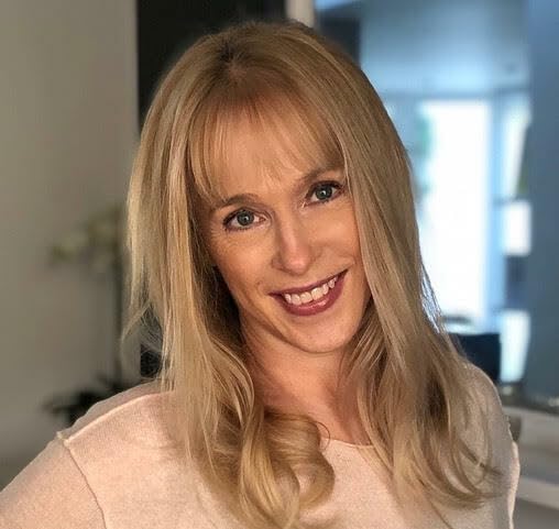 Blonde woman with shoulder-length hair smiling at the camera.