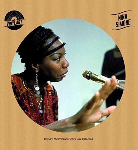 Nina Simone singing into a microphone in a circular frame on cardboard background.