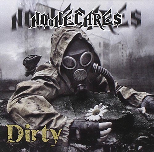 Figure in gas mask lying amongst rubble, holding a daisy.