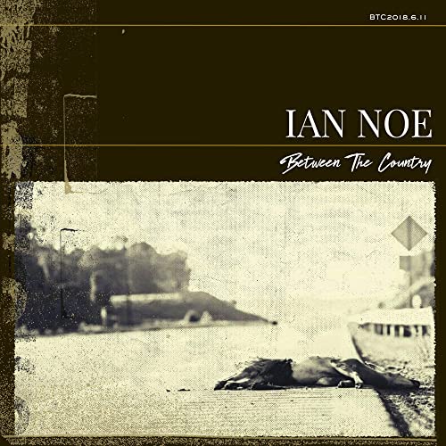 Album cover for Ian Noe’s “Between The Country” with a blurred roadside scene.