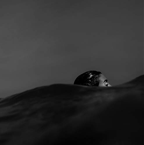 Black and white portrait of a person partially submerged in water.