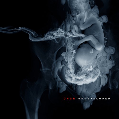 Dark album cover featuring a fetal form amidst swirling smoke.