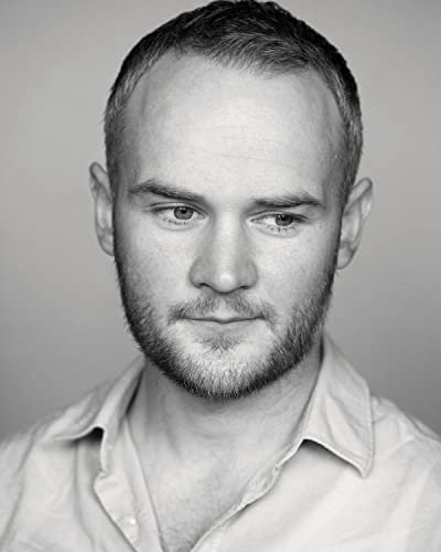 Black and white headshot of a young man with short hair and beard.