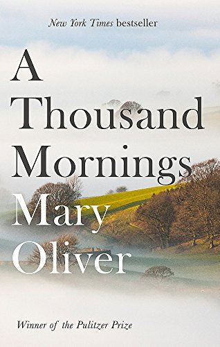Book cover with serene landscape and title A Thousand Mornings by Mary Oliver.