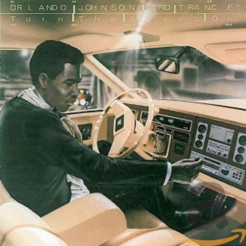 CD cover: man driving a car, looking at a radio.