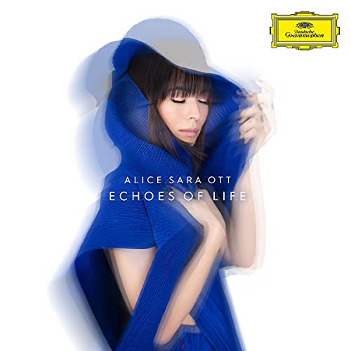 Woman in blue sweater with eyes closed, holding fabric, on a white background, with logo.