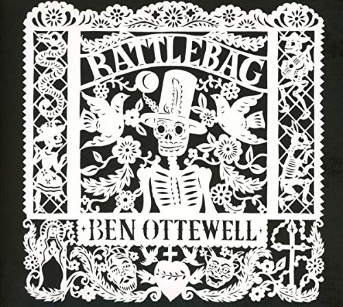 Intricate white papercut design of a skeleton with birds and flowers.