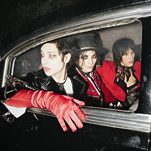 Three band members in dark clothing look out from a car window.