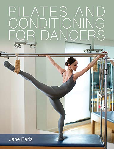 A dancer in a grey leotard performs a Pilates exercise on a reformer machine.