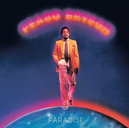 Peabo Bryson in a yellow suit walking on a globe against a dark background.