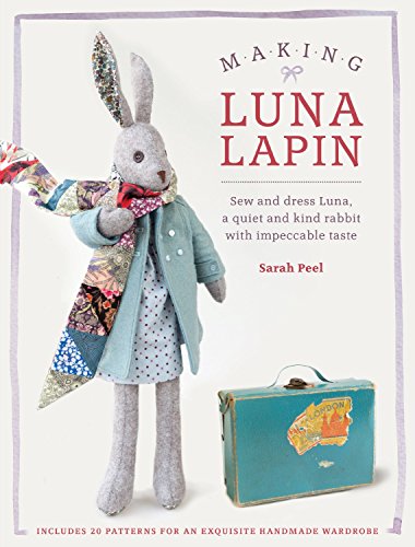 Grey fabric rabbit doll wearing a coat and scarf, with a suitcase.