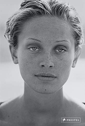 Black and white portrait of a woman with freckles, looking directly at the viewer.