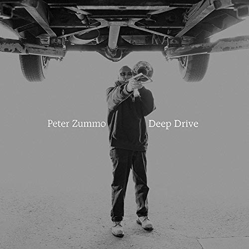 Black and white vinyl album cover with a man under a car's undercarriage.