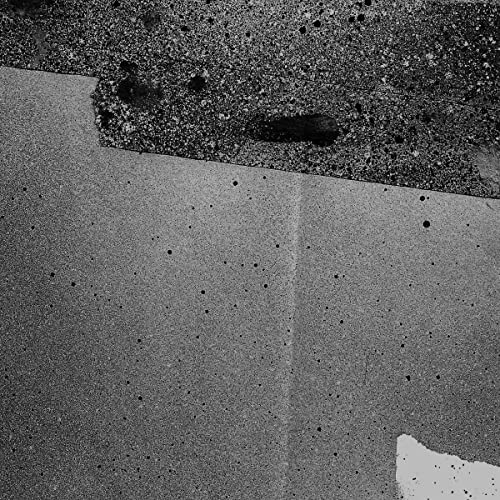 Black and white abstract image of textured, grainy surfaces.