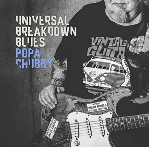 Black and white photo of man with guitar and tattooed arm wearing a t-shirt.