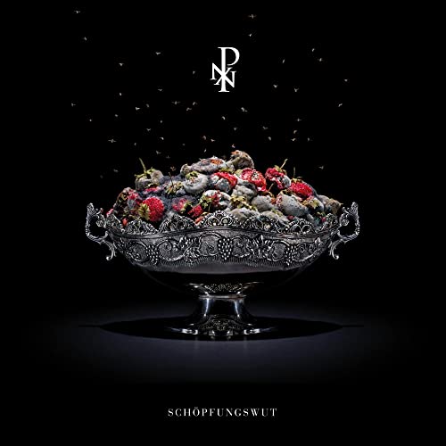 Silver bowl overflowing with strawberries and dark, granular material.