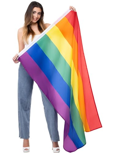 A woman holding a large rainbow pride flag against a white background.