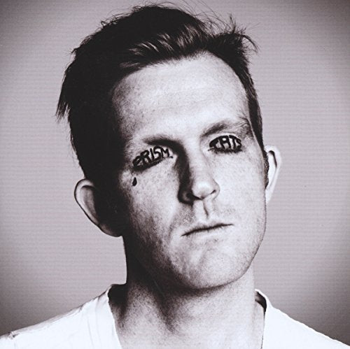 Black and white portrait of a man with "PRISM TATS" written on his face.
