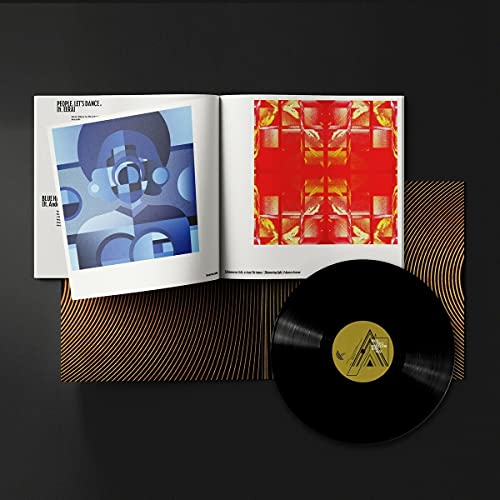 An open vinyl record sleeve with an art booklet and a black vinyl disc.