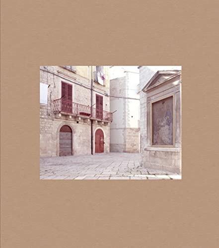 Stone buildings with red doors and a religious icon in Puglia.