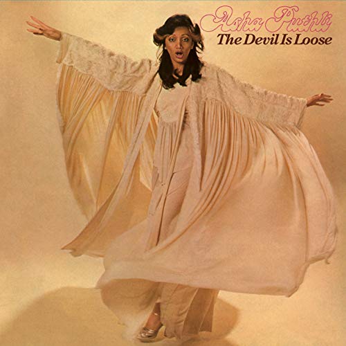 Album cover featuring a woman in flowing white dress, arms outstretched, against orange background.