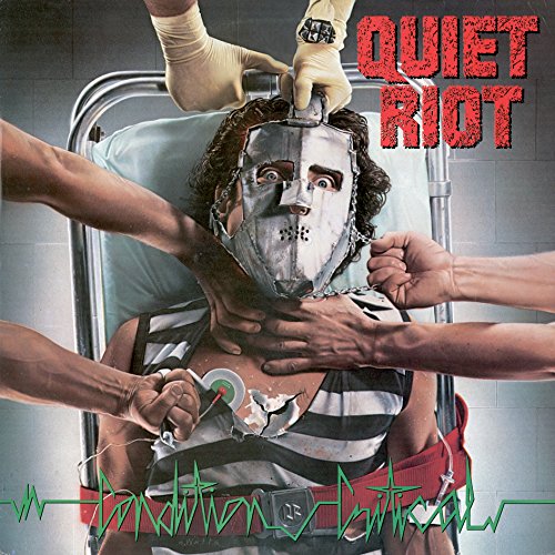 Album cover: man with a metal mask being worked on by gloved hands.