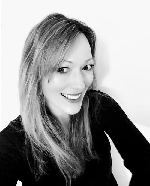 Black and white portrait of a smiling woman with long hair.