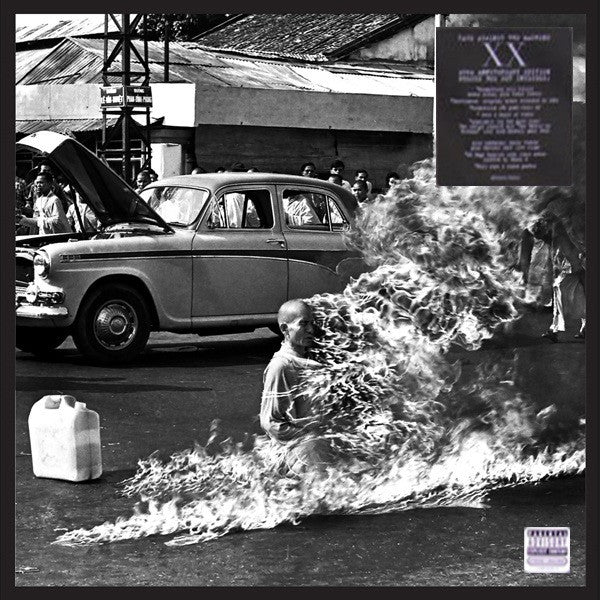 Black and white image of a person engulfed in flames near a car.