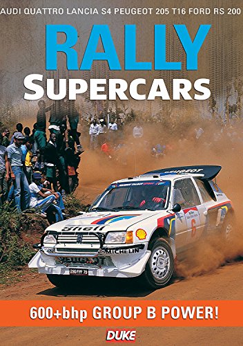 A Peugeot 205 T16 rally car kicks up dust near spectators on a dirt track.